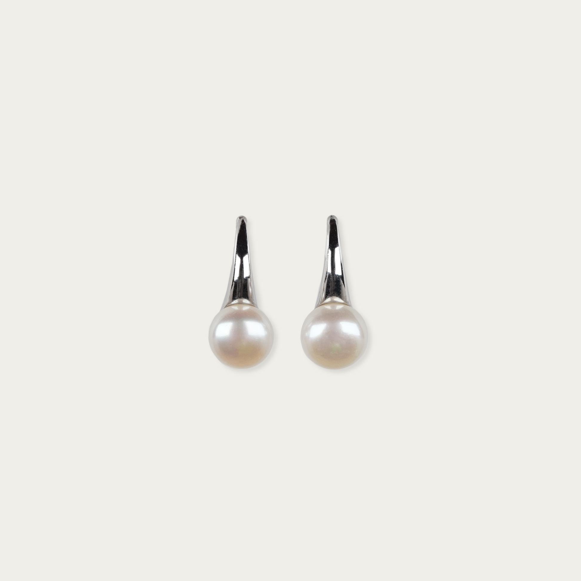 Sculptural sterling silver earrings with 8mm freshwater pearls, 3/4-inch drop, hook backing.