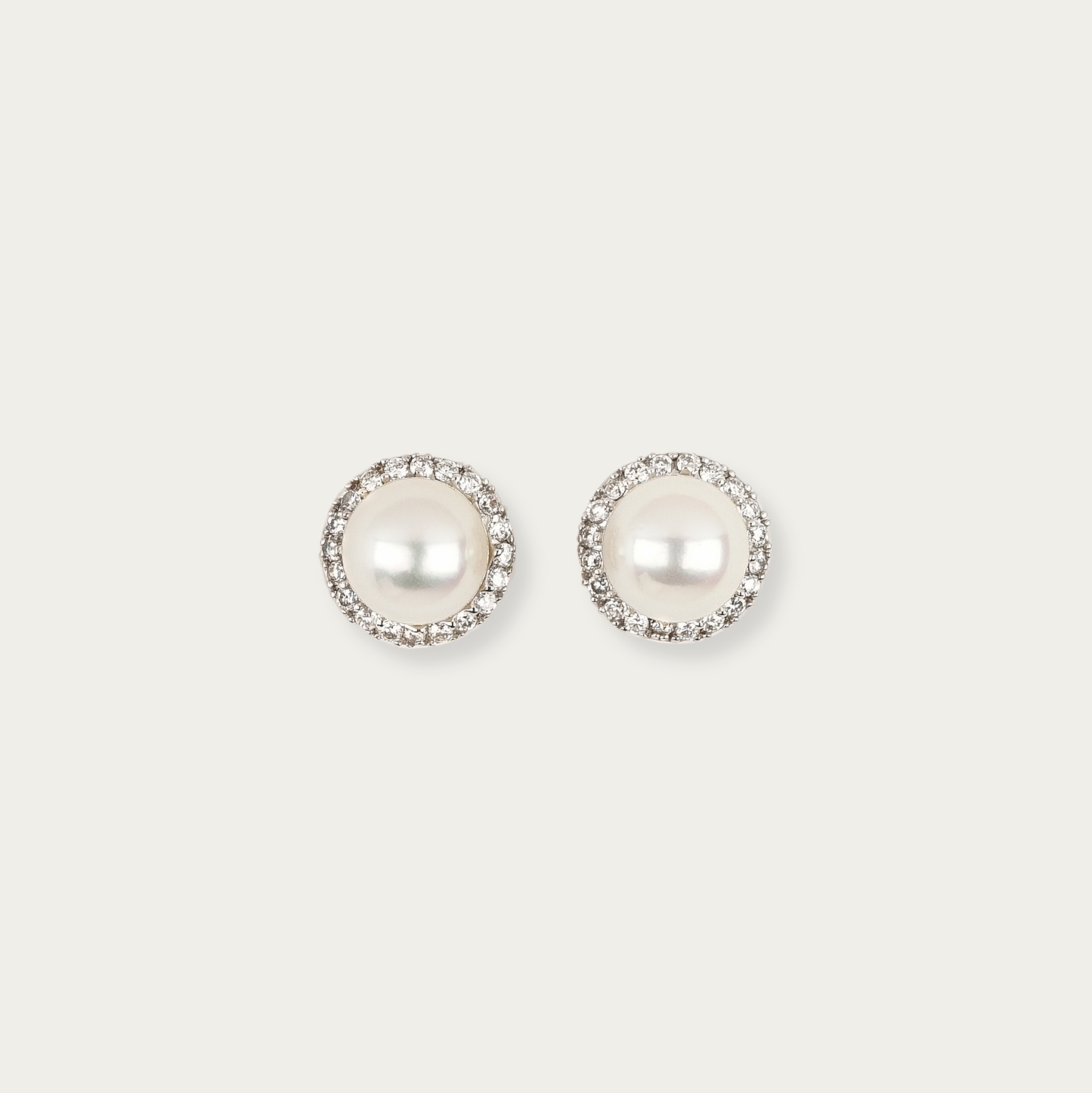 Solis Earrings in 18k white gold with 7mm cultured white pearls surrounded by a halo of diamonds, 9mm total width, post and butterfly back closure.